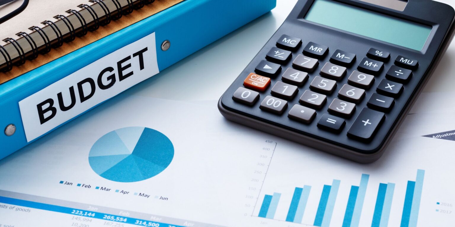 This is a stock photo showing a calculator and a binder that says "Budget" on the side.