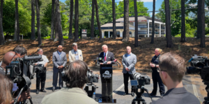 This is a photo of Mayor Kurt Wilson and City leaders at a press briefing in front of the Economy Hotel.