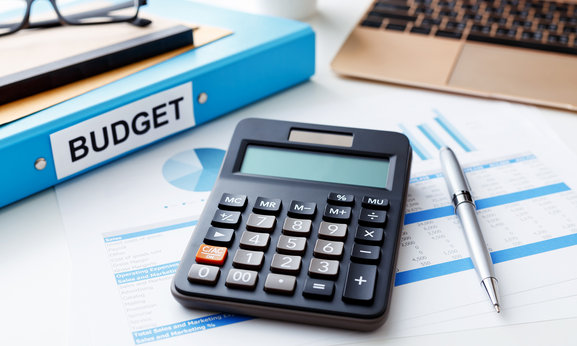 Calculator on a desk with a budget book