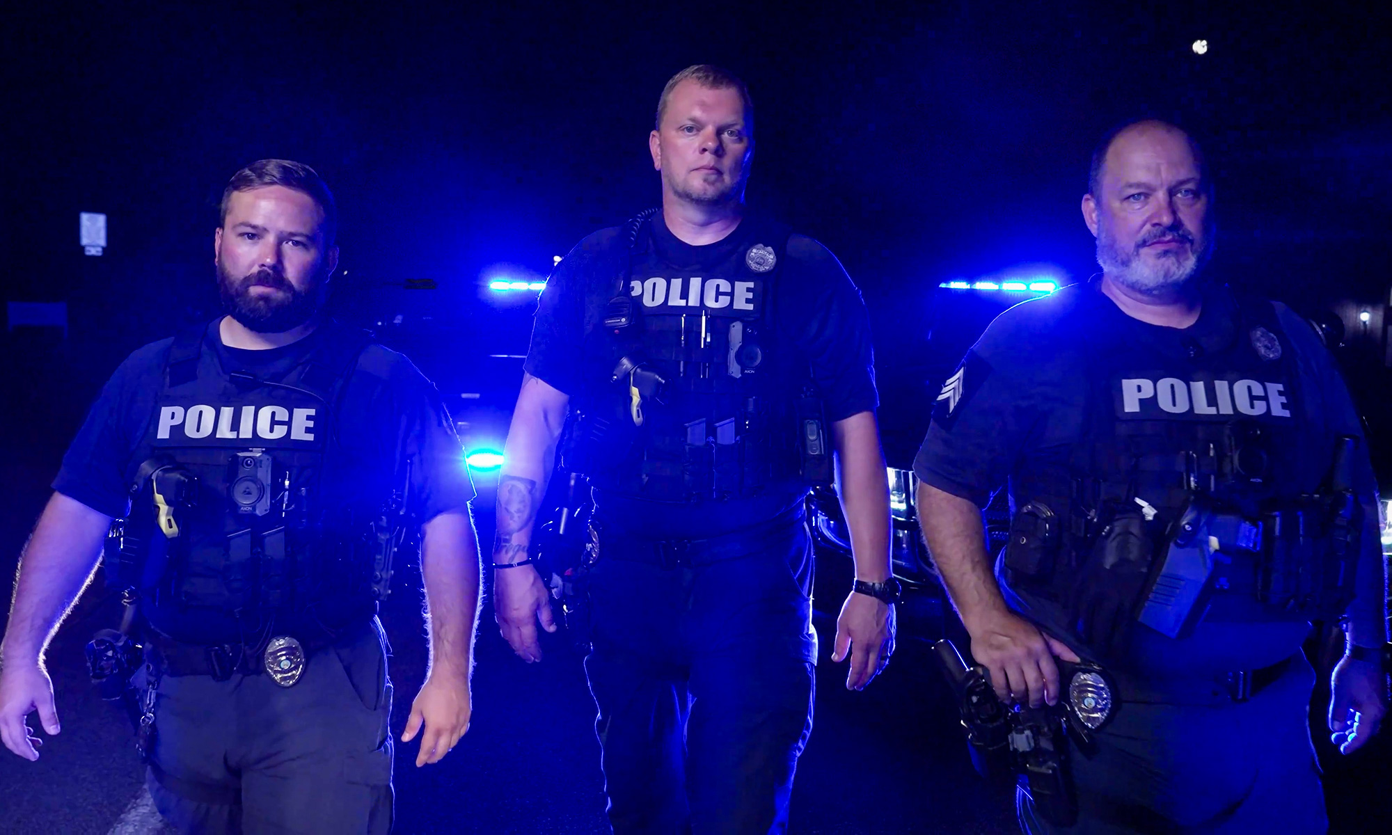 Roswell Police Department Three Officers With Sqaud Car Lights