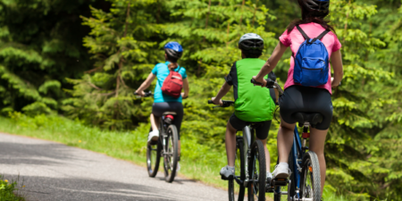 Family of three bikes on path