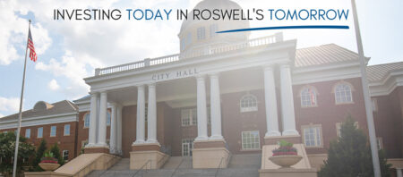 Front of Roswell City Hall building with text that reads Investing Today in Roswell's Tomorrow
