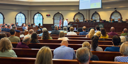 Mayor and Council Meeting Recap: July 27, 2026 Members of the public sit in pews during a meeting at Roswell City Hall in Council Chambers.
